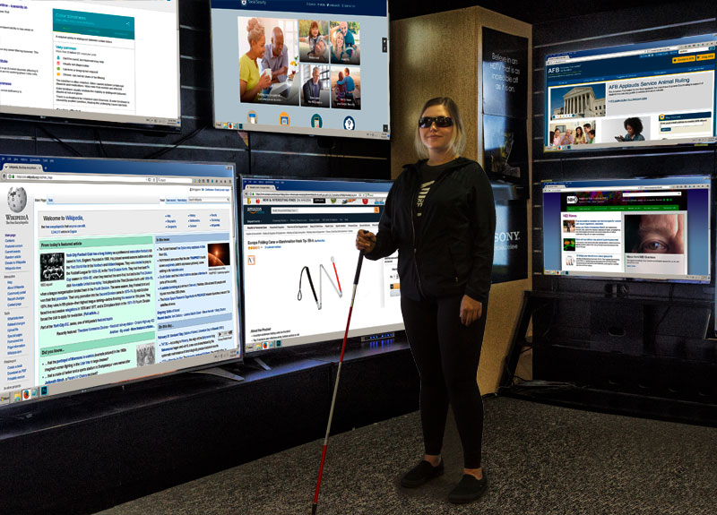 Peter Shikli, CEO, leans against at desk surrounding by a dozen working analysts sitting at computer desks.